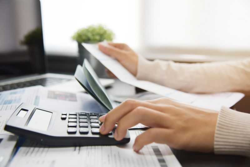 close up of person calculating expenses using a calculator