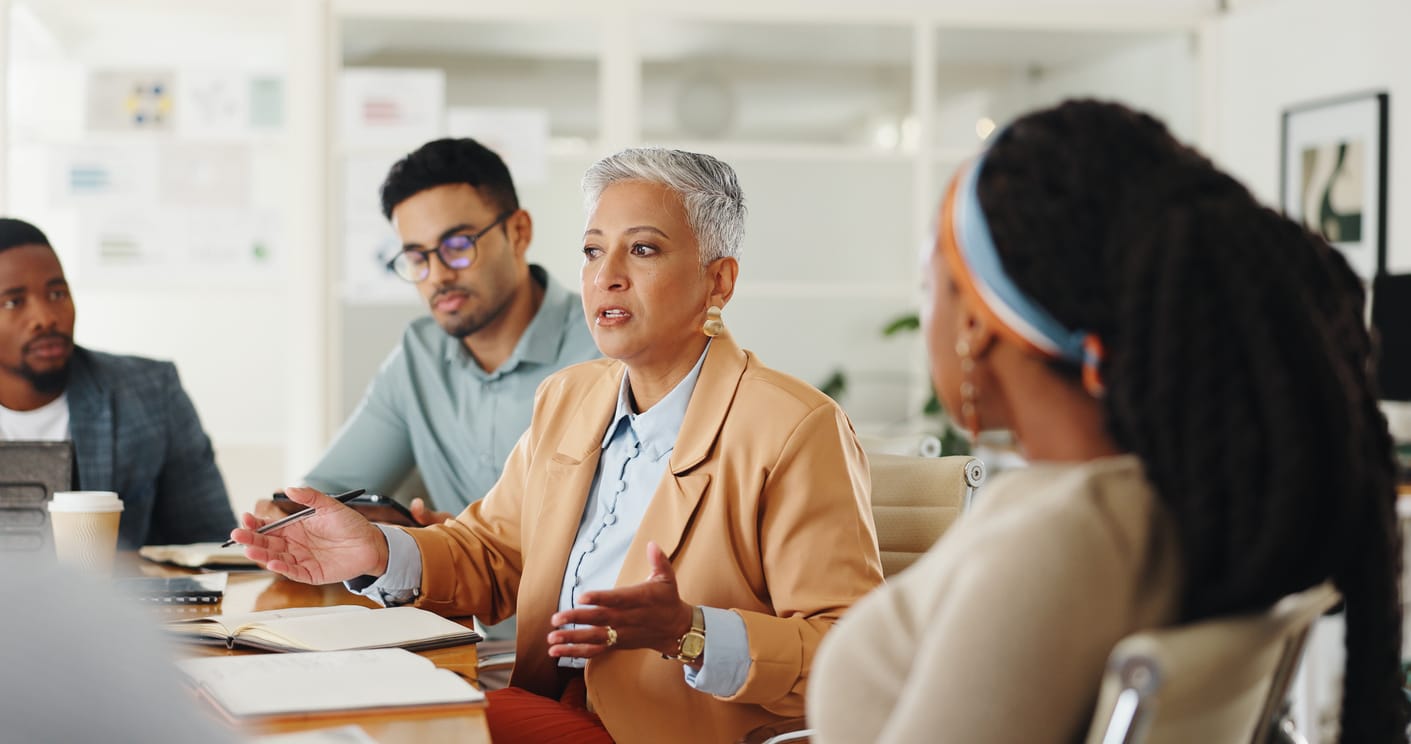 group of employees sat in a meeting room discussing the impact of business change