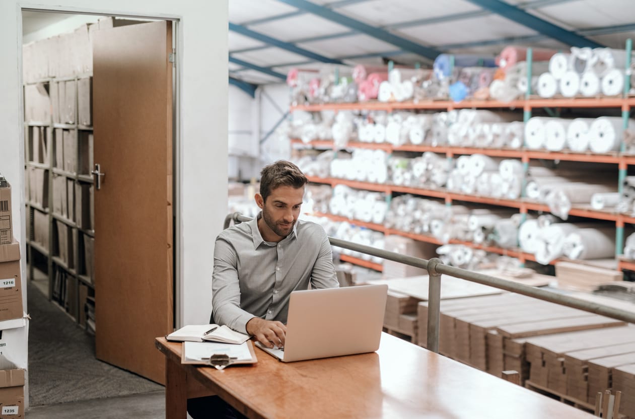 business owner sat in warehouse completing admin
