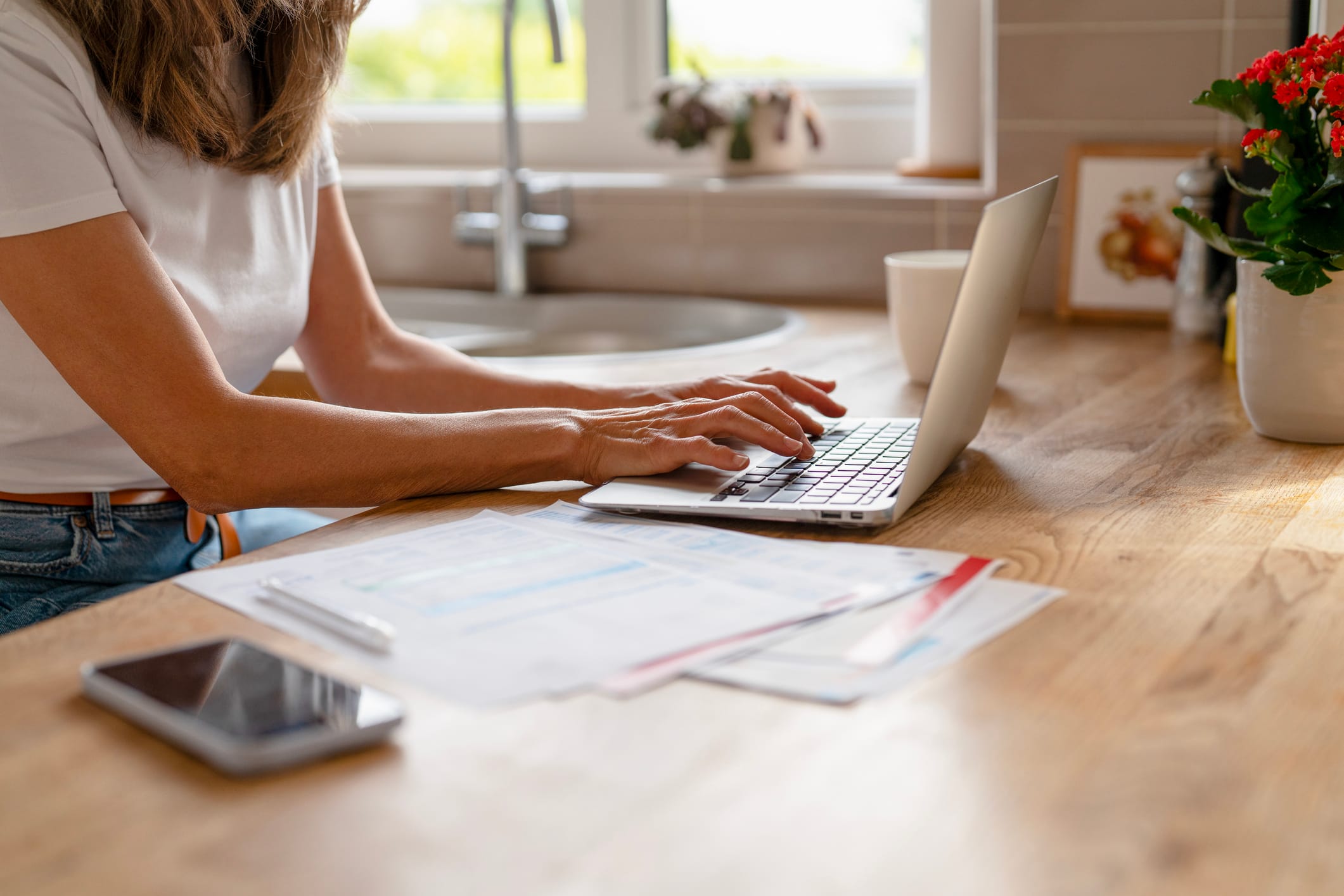 woman sat at breakfast bar making payment on her laptop